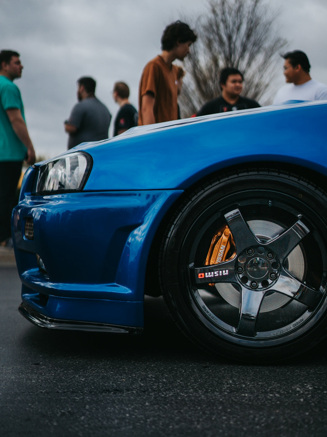 Blue sports car with people in the background